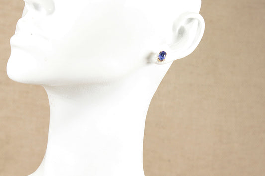 Gold blue topaz stud earring in the ear of a white mannequins head 