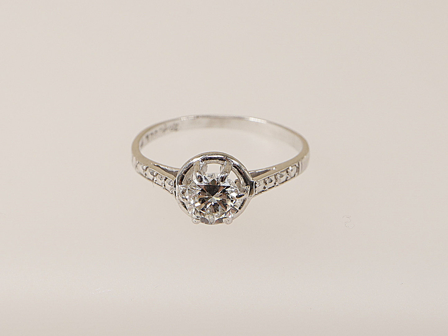 An 18ct white gold diamond solitaire ring with a central diamond set in a six-claw crown setting, surrounded by smaller diamonds on the shoulders. This ring would make an ideal engagement ring for your loved one! 
Diamond diameter: 5mm, Diamond weight: 0.50ct (estimated), UK Finger size N.