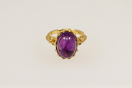This 9ct Gold ring is a truly magnificent vintage statement with regal presence!
It features a large, high-domed oval cabochon Amethyst with a deep purple colour, set in an intricate gold basket crown setting. UK finger size P.