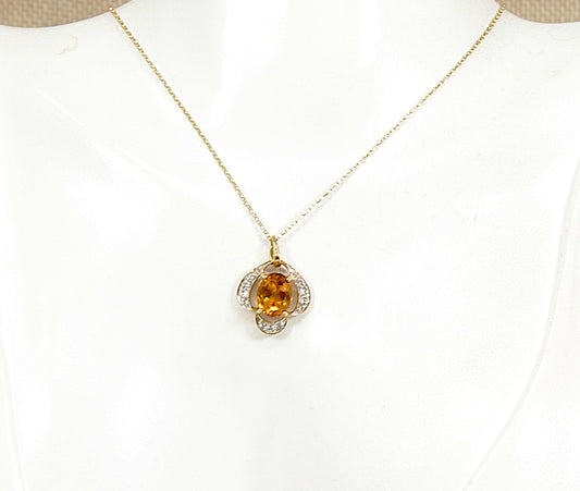 A gold chain necklace with a flower-shaped pendant featuring a central round citrine gemstone and small clear white citrine accent gemstones, displayed on a white jewelry bust.