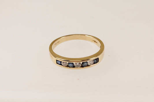 9ct yellow gold channel set blue sapphire and diamond band ring, UK finger size N.
