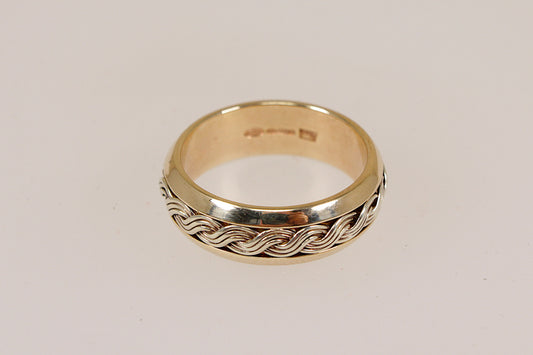 Gold ring with braided woven lives design on a light gray background