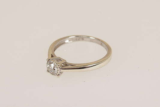 White gold diamond solitaire ring on a light beige background
