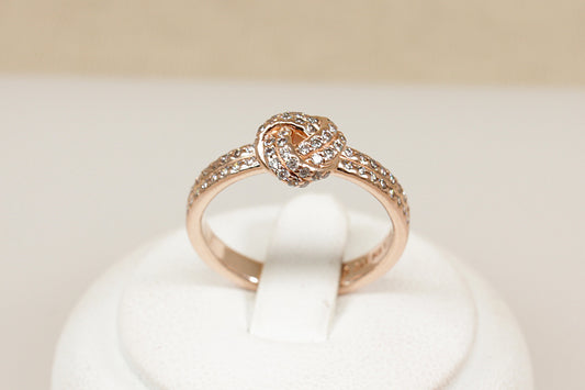 Silver gilt pandora ring sitting on a white display stand