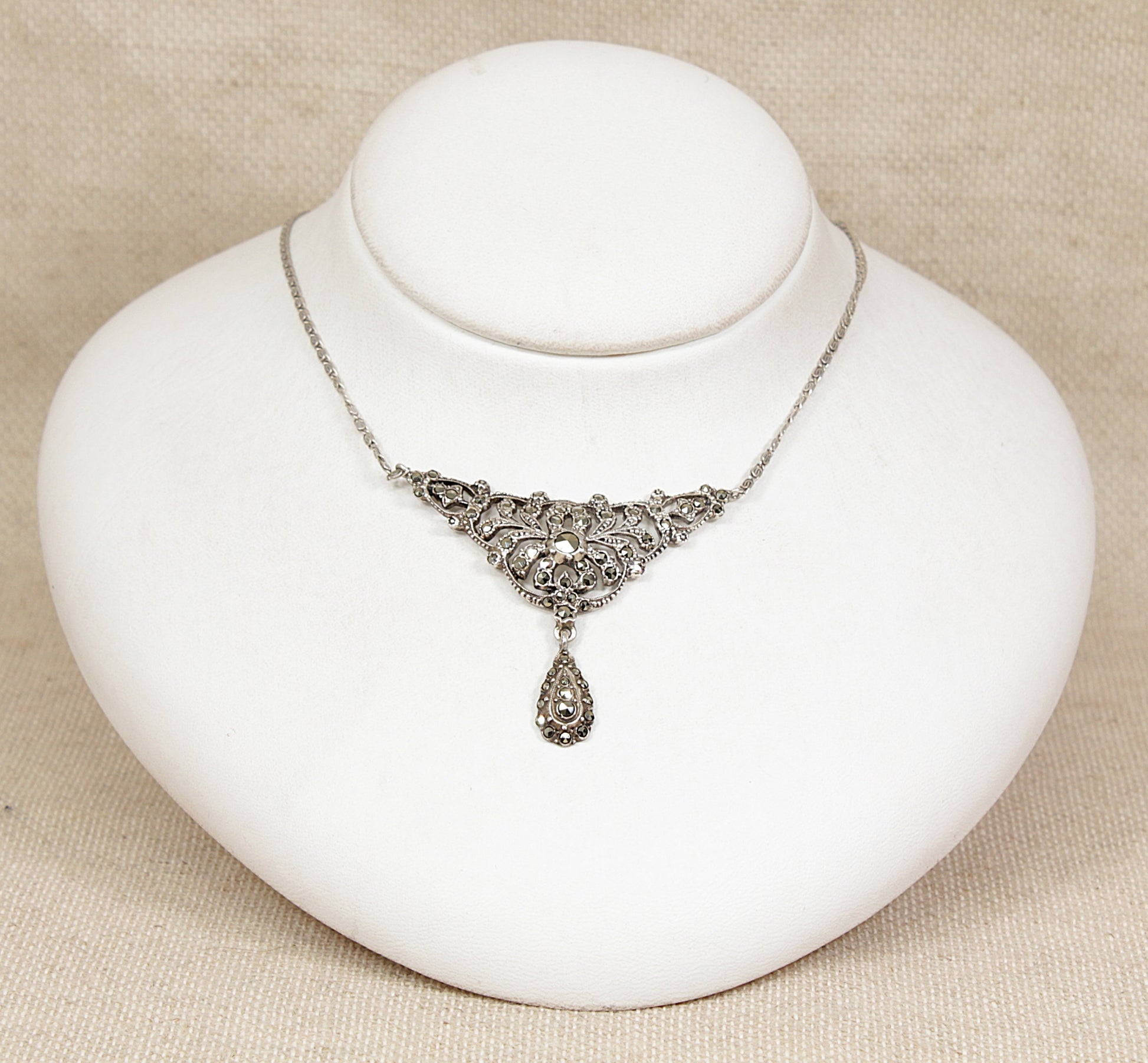 Silver art deco marcasite necklace on a white jewelry display