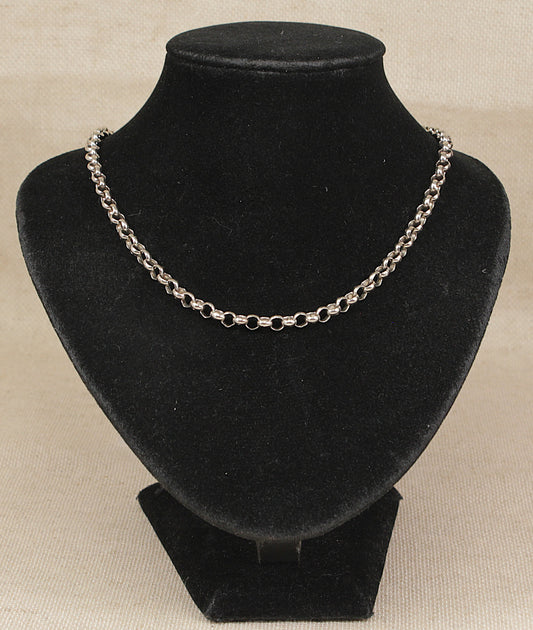 A vintage sterling silver neck chain necklace displayed on a black velvet jewelry bust against a light beige textured background.