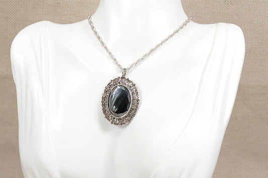 Necklace with an oval hematite  pendant on a mannequin against a beige background