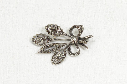 Vintage Silver marcasite brooch with intricate design on a white background