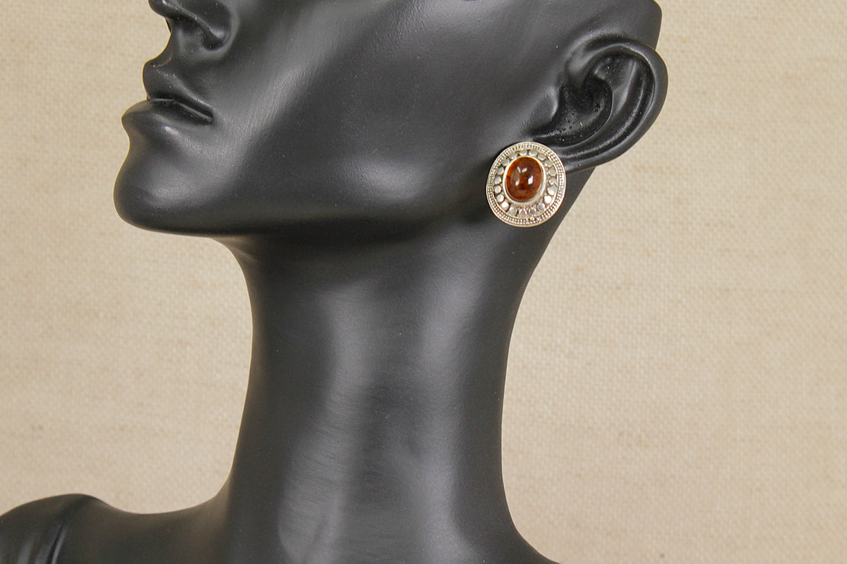 Earring on a mannequin head with a beige background