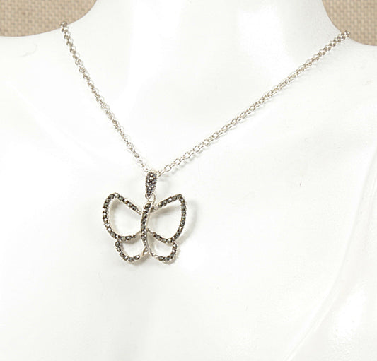 A silver butterfly pendant necklace displayed on a white mannequin bust. The necklace features a delicate silver chain and a butterfly-shaped pendant encrusted in sparkling marcasite  finish.