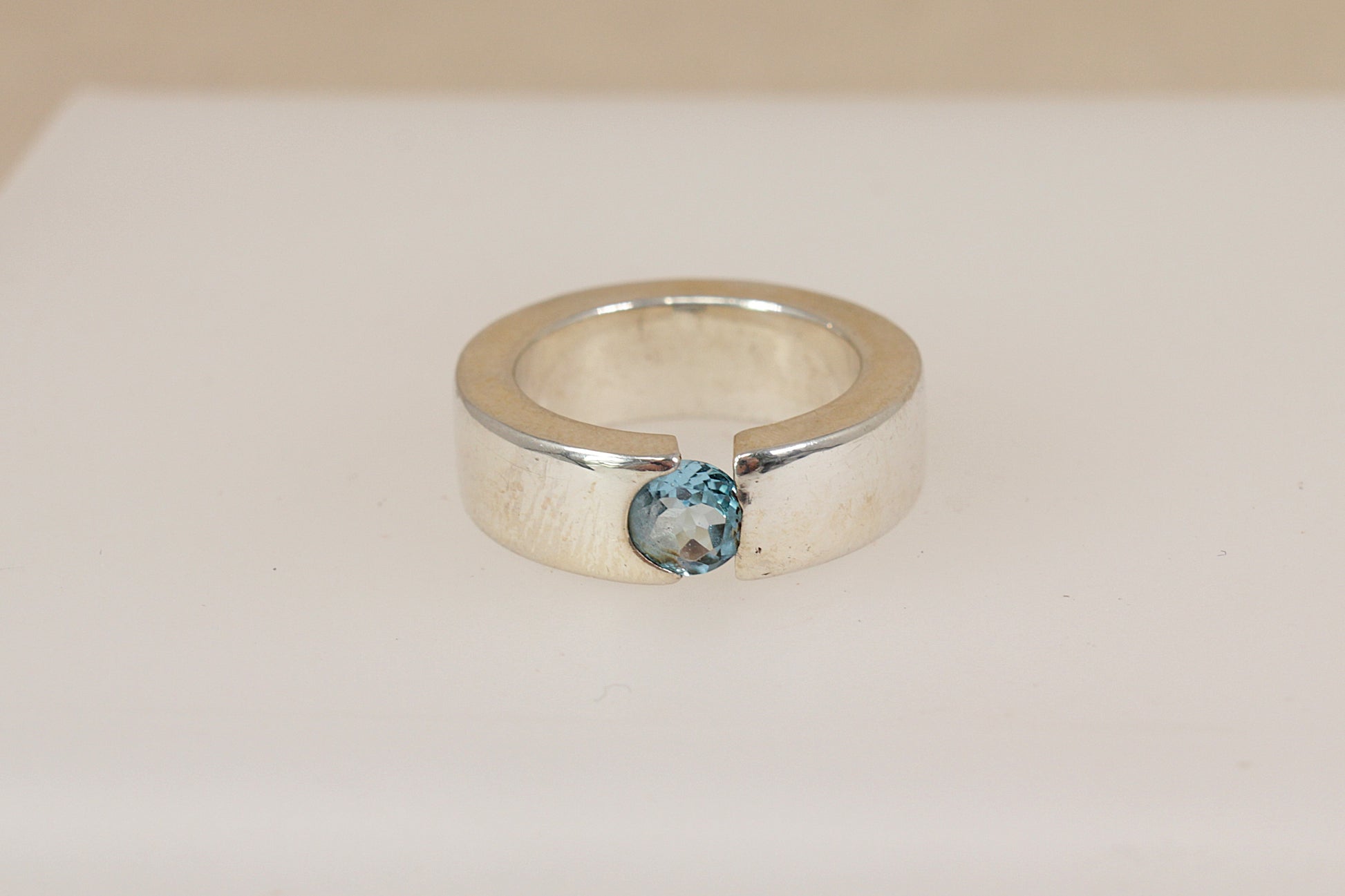 Silver statement ring with a blue topaz gemstone on a white background