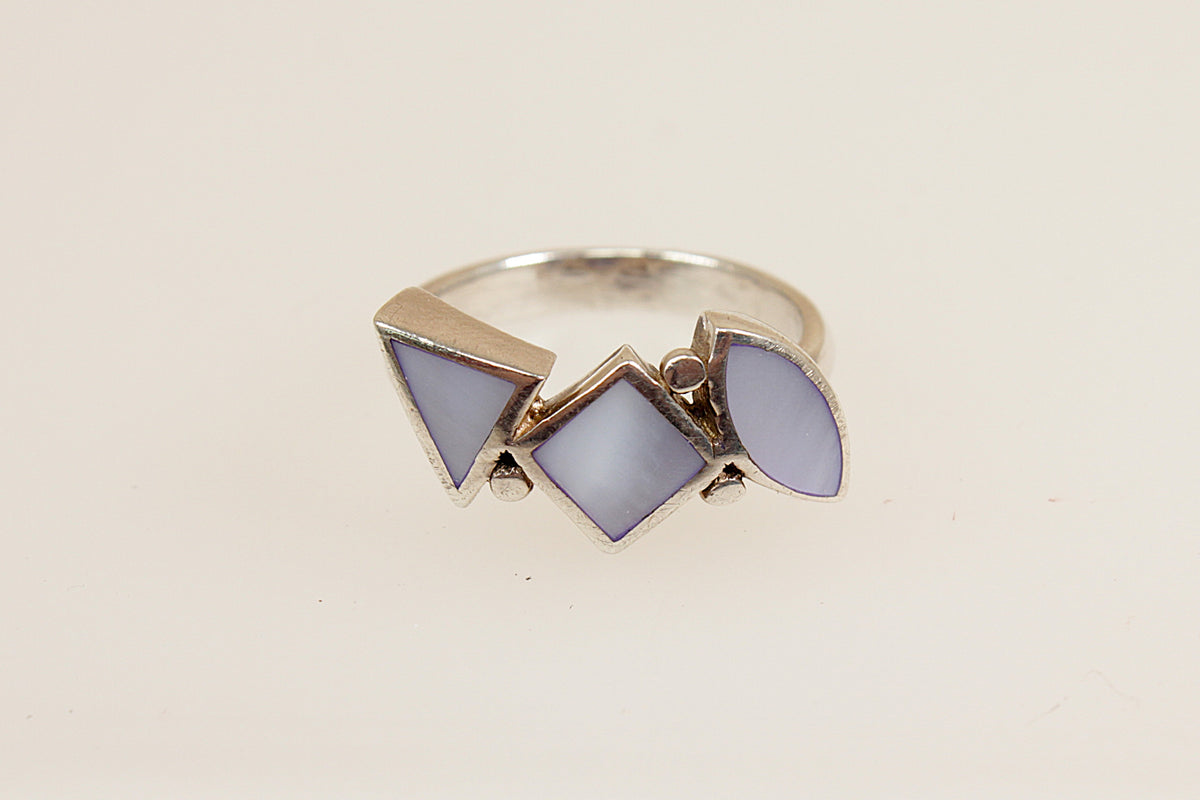 Silver ring with mother of pearl  gemstones on a beige background