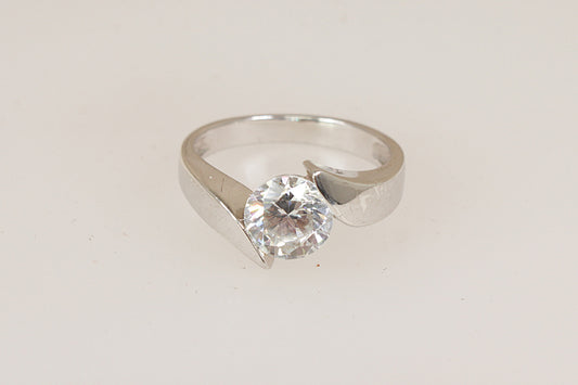 Silver solitaire ring with a simulated  diamond cubic zirconia gemstone on a light gray background
