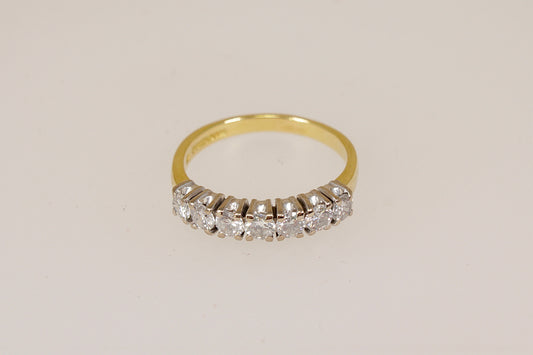 18ct 7 stone diamond eternity ring on a light beige background