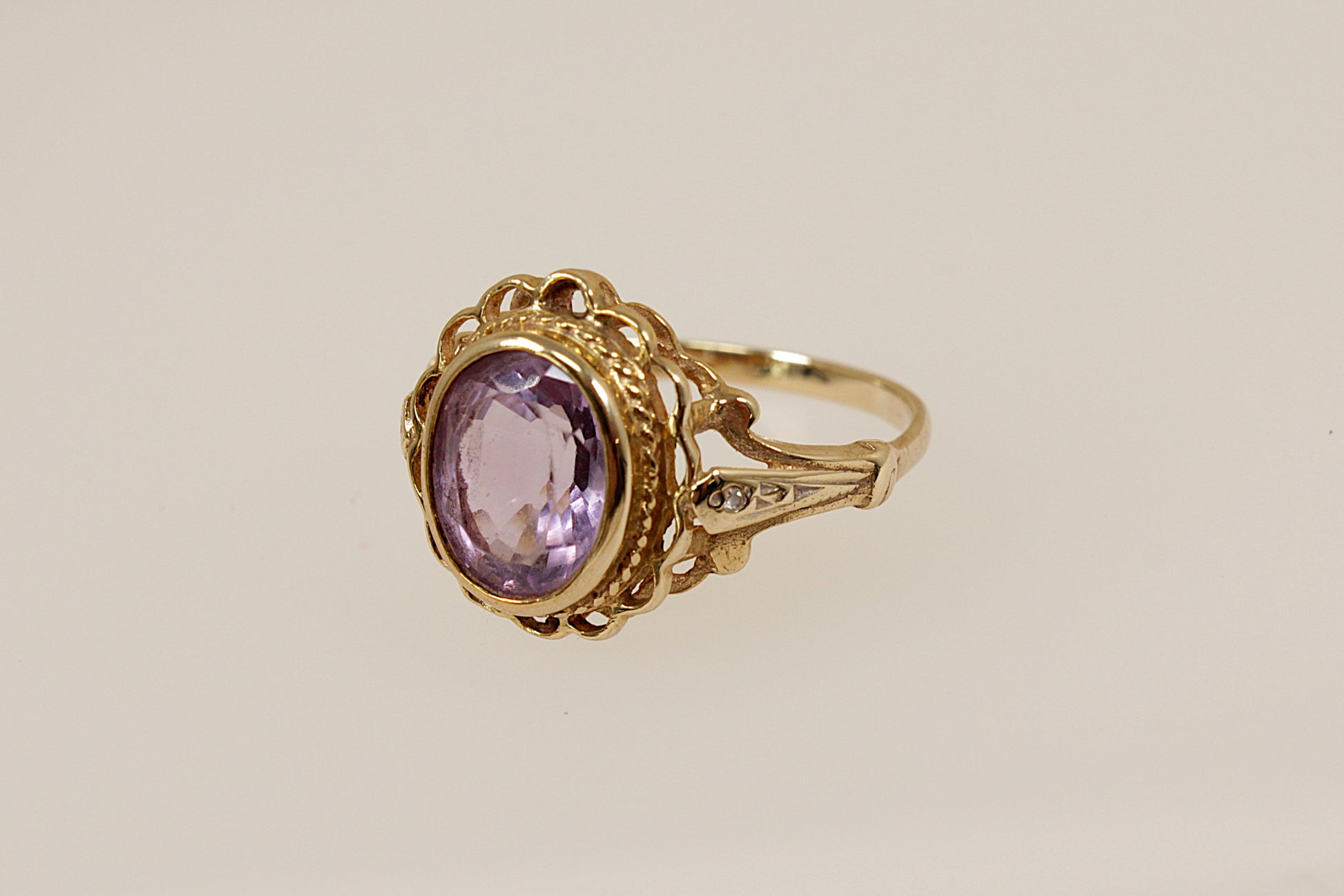 Vintage Gold ring with a purple amethyst gemstone on a beige background