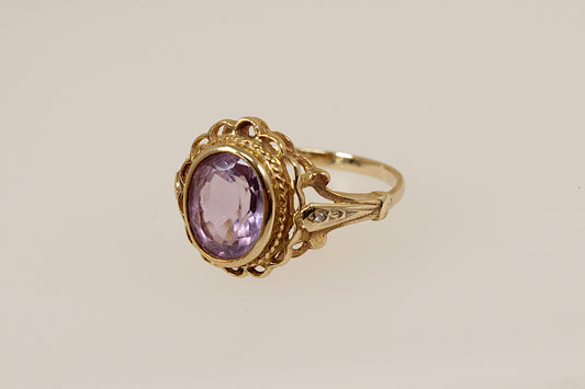 Vintage Gold ring with a purple amethyst gemstone on a beige background