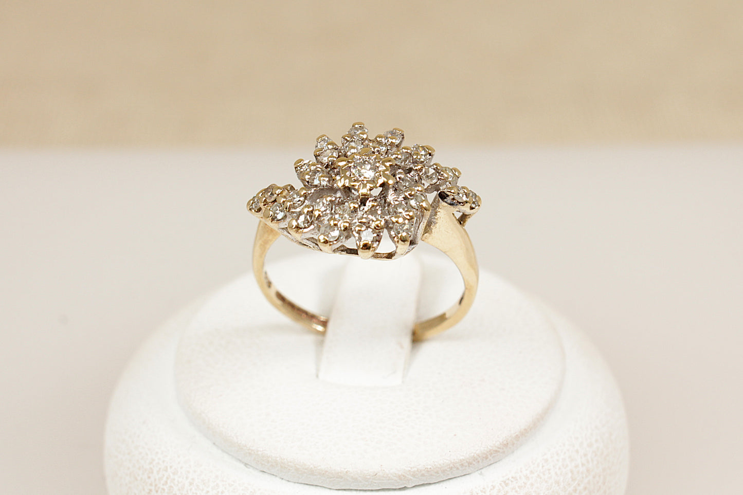 A stylish and bold vintage 9ct yellow Gold Diamond cluster ring. The eye-catching design features a raised basket setting adorned with 29 sparkling round-cut diamonds, centred by a slightly larger diamond. Fully hallmarked inside the band for Birmingham, 1981, confirming 9ct Gold purity and British craftsmanship. UK finger size N.