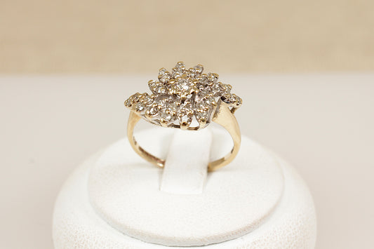 A stylish and bold vintage 9ct yellow Gold Diamond cluster ring. The eye-catching design features a raised basket setting adorned with 29 sparkling round-cut diamonds, centred by a slightly larger diamond. Fully hallmarked inside the band for Birmingham, 1981, confirming 9ct Gold purity and British craftsmanship. UK finger size N.