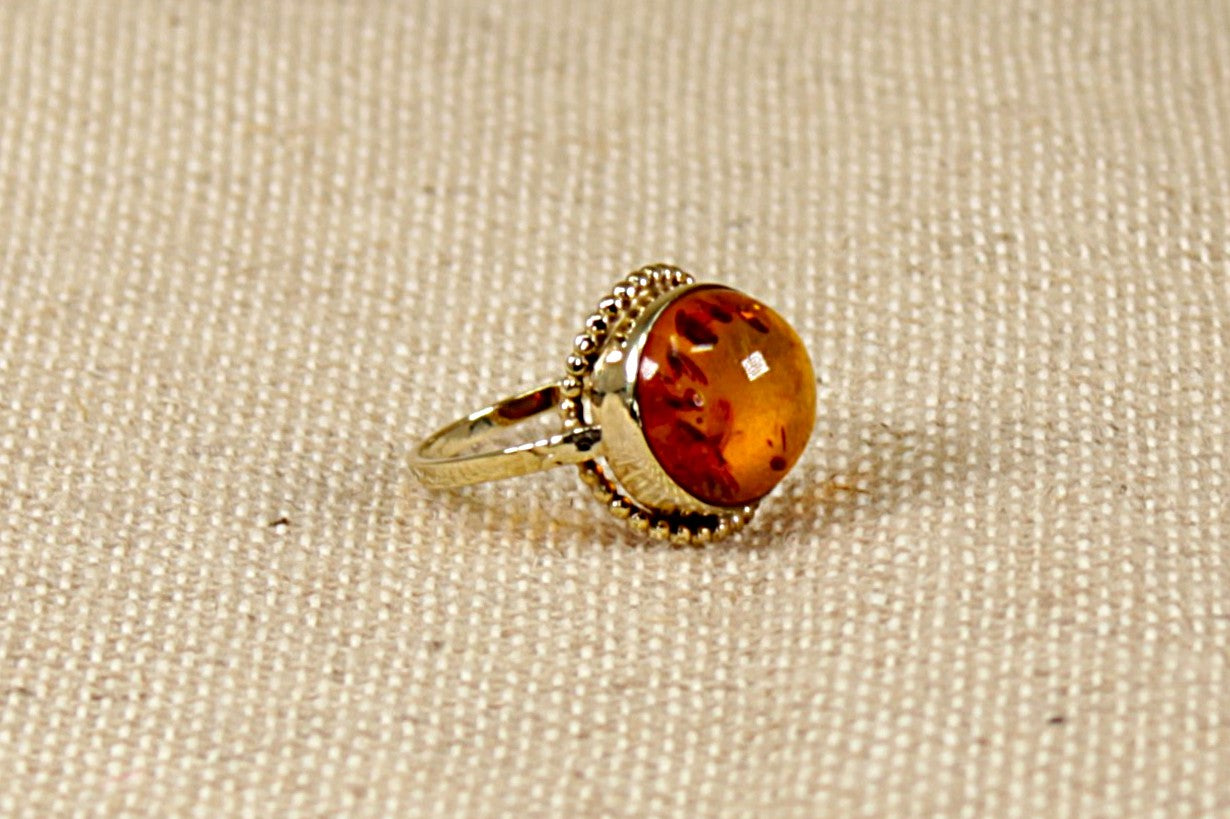 This stunning vintage ring has a round cabochon Amber set in a finely made Gold setting. The Amber is displaying inside many Fossils trapped in time. 
The ring is stamped 333 inside the band for 8ct Gold. In our opinion this ring is circa 1930’s and possibly continental in origin. UK Finger size N.